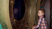 A child looking out of a ship's porthole